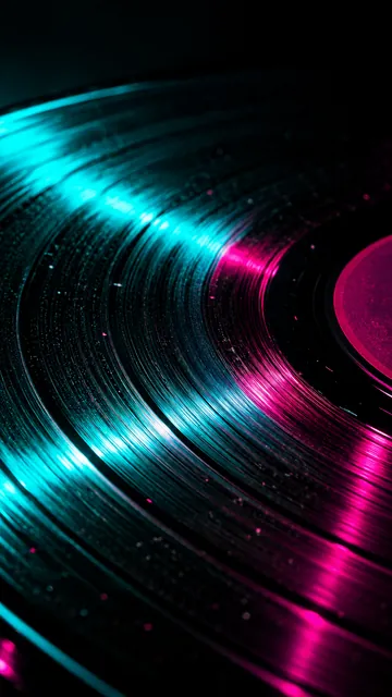 Spinning vinyl record grooves streaked with teal and magenta neon light